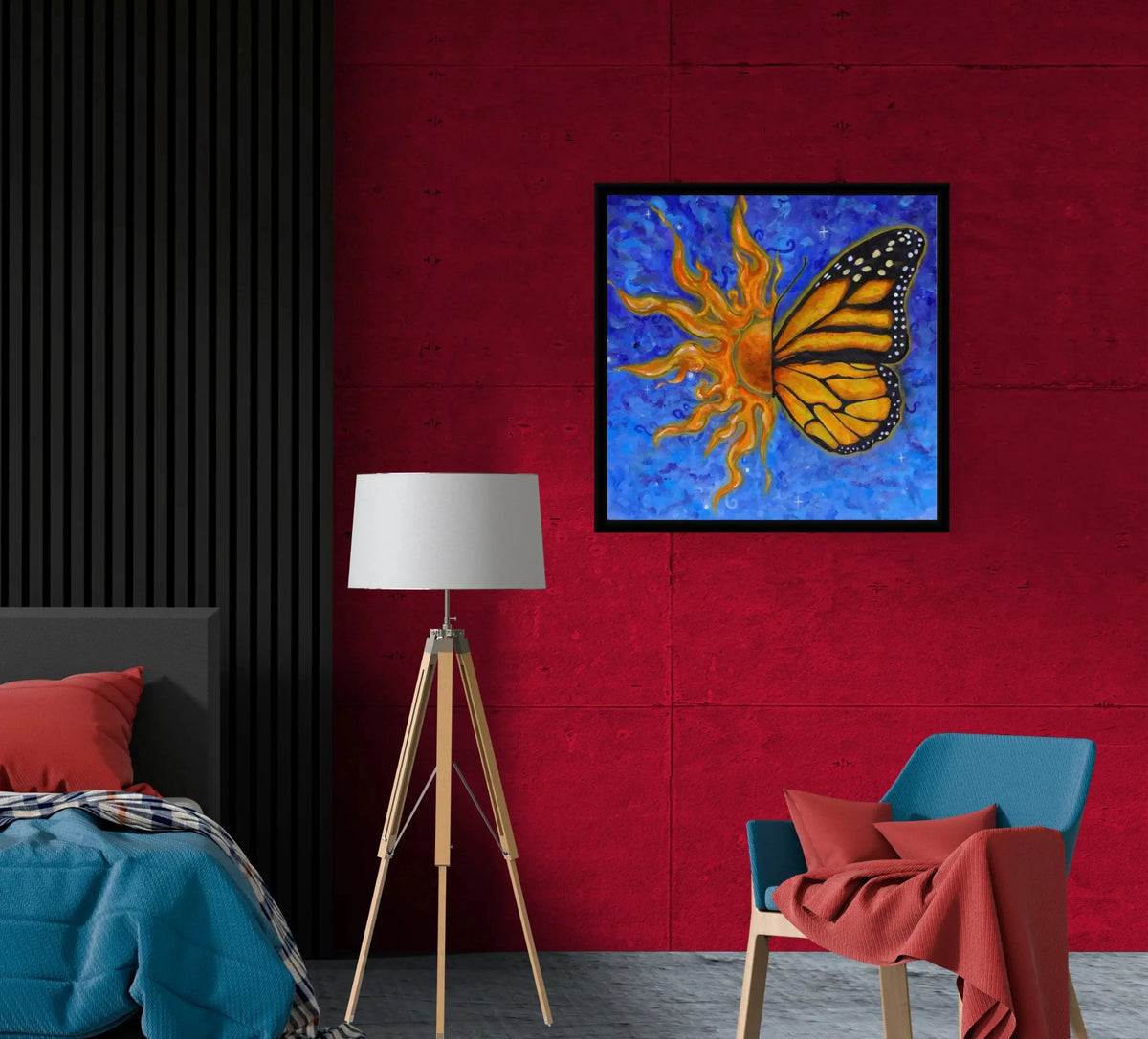 A framed square wall art print showing a stylized half sun and half orange and black butterfly on a bright blue textured background, displayed in a modern bedroom setting with a red wall, black slatted headboard, floor lamp, and blue chair.